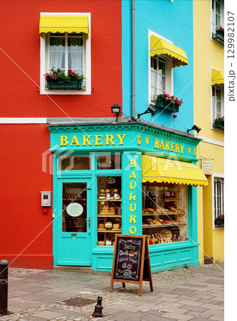 カラフルな街角に佇むパン屋と華やかな建物の風景 129982107