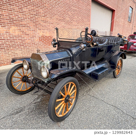 Classic Vintage Ford Model T Car Parked on a Quiet Street With Brick Buildings Classic Vintage Ford Model T Car Parked on a Quiet Street With Brick Buildings 129982643