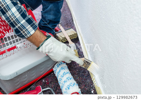 House painter worker painting a wall white. Building. House painter worker painting a wall white. Building. 129982673