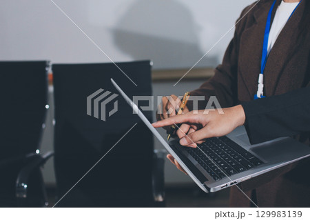 Focused young businessman signing agreement with skilled lawyer in eyeglasses. Concentrated financial advisor showing place for signature on paper contract document to male client at meeting in office Focused young businessman signing agreement with skilled lawyer in eyeglasses. Concentrated financial advisor showing place for signature on paper contract document to male client at meeting in office 129983139