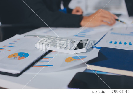 Focused young businessman signing agreement with skilled lawyer in eyeglasses. Concentrated financial advisor showing place for signature on paper contract document to male client at meeting in office Focused young businessman signing agreement with skilled lawyer in eyeglasses. Concentrated financial advisor showing place for signature on paper contract document to male client at meeting in office 129983140