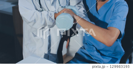 Person using hand weight with support of nurse 129983193