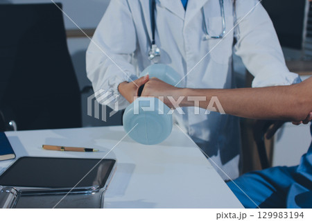 Person using hand weight with support of nurse 129983194
