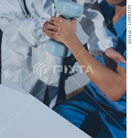 Person using hand weight with support of nurse 129983195