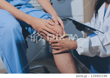 Physical therapist teaching a patient how to do exercises for his knee pain Physical therapist teaching a patient how to do exercises for his knee pain 129983196