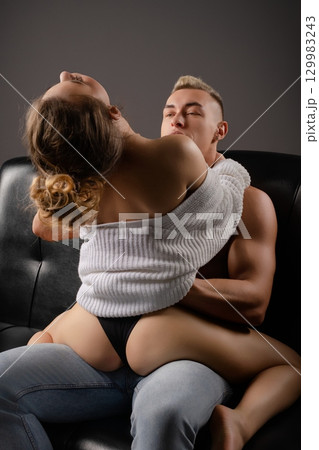 Couple enjoying intimate moment on a couch in cozy setting Couple enjoying intimate moment on a couch in cozy setting 129983243