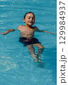 A young boy is swimming in a pool 129984937