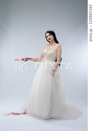 Bride in white lingerie with knife in a haunting display of beauty and danger Bride in white lingerie with knife in a haunting display of beauty and danger 129985383