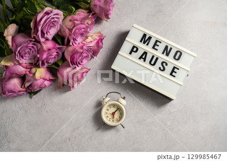 Word Menopause with pink roses and alarm clock, flat lay, grey background Word Menopause with pink roses and alarm clock, flat lay, grey background 129985467