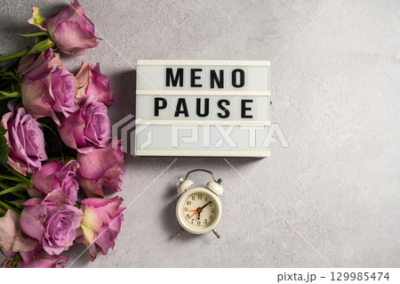 Word Menopause with pink roses and alarm clock, flat lay, grey background Word Menopause with pink roses and alarm clock, flat lay, grey background 129985474