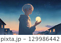 夜明け前の静かな街の中、男性の手には小さな光の粒が握られている。希望のイメージ。 129986442