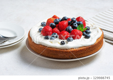 Sponge cake with cream cheese and fresh berries 129986745