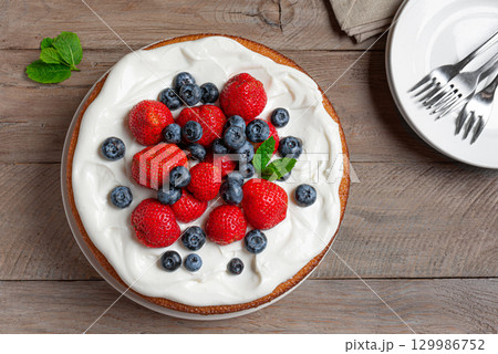 Sponge cake with cream cheese and fresh berries 129986752