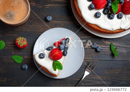 Sponge cake with whipped cream and fresh berries 129986772