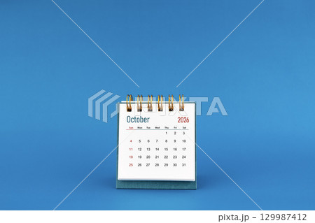 October 2026 mini desk calendar on blue color background. October 2026 mini desk calendar on blue color background. 129987412