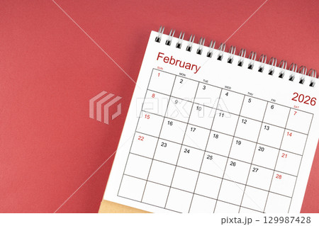 February 2026 desk calendar on red color background. Flat lay. 129987428