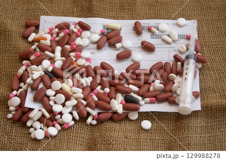 syringe and pills on medical document 129988278