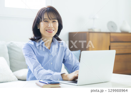 リビングでテレワーク中のミドル女性 129988964