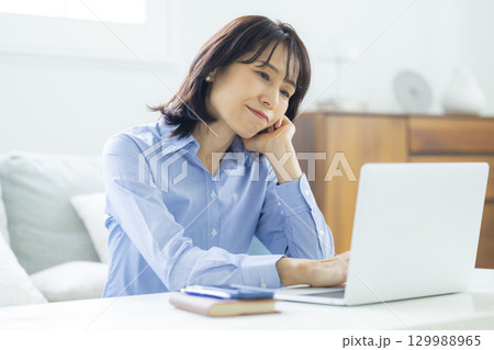 リビングでテレワーク中のミドル女性 129988965