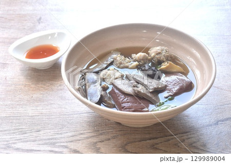 boiled pork blood and entrails with chop pork topping black mushroom in soup on bowl dipping spicy sour chili sauce  129989004