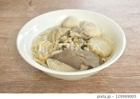 boiled vermicelli thin rice noodles topping pork ball and entrails with chop pork in clear soup on bowl  129989005