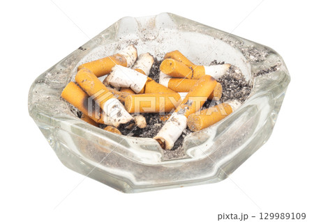 A glass ashtray with extinguished cigarette butts inside on a white background 129989109