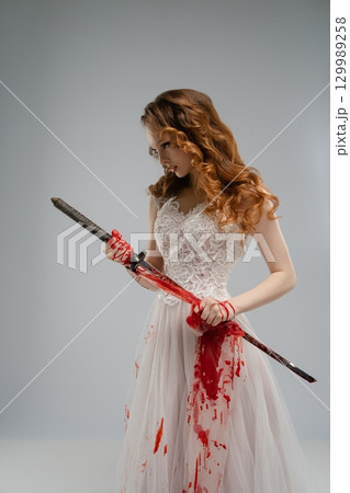 Bridal gown-clad woman wields bloodied katana, mixing beauty and violence Bridal gown-clad woman wields bloodied katana, mixing beauty and violence 129989258