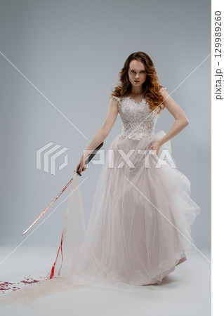 Beauty in white lace holding a katana with a hint of tragedy and mystery 129989260