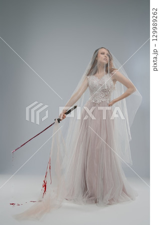 Beautiful bride in lingerie wielding katana with blood on her gown Beautiful bride in lingerie wielding katana with blood on her gown 129989262