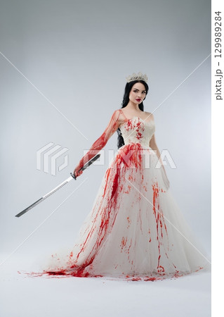 Bride in blood-soaked lingerie holds knife with a sinister aura Bride in blood-soaked lingerie holds knife with a sinister aura 129989284