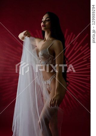 Elegance of a bridal beauty in luxurious lingerie against a bold backdrop Elegance of a bridal beauty in luxurious lingerie against a bold backdrop 129989294