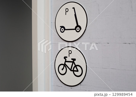 Parking signs for scooter and bicycle in urban environment. Clear and simple symbols indicating parking spots, ideal for city planning, urban transportation and sustainable mobility solutions 129989454