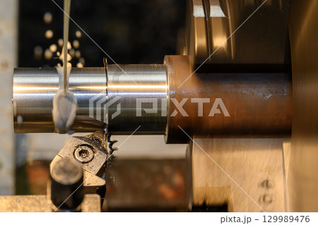 The lathe machine finish cut metal shaft parts with liquid coolant method. 129989476