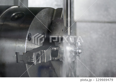The 5-axis CNC milling machine cutting the automotive parts with liquid coolant method. The 5-axis CNC milling machine cutting the automotive parts with liquid coolant method. 129989479