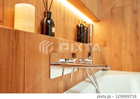 Modern chrome faucet and shower in wooden style bathroom interior 129989718