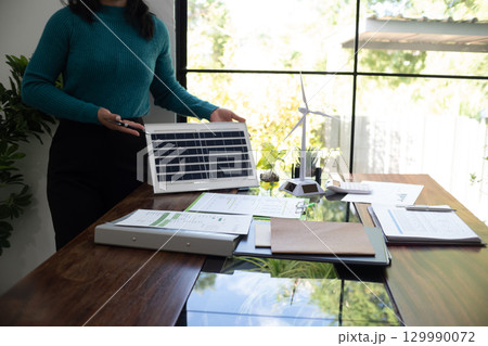 A sales representative presenting solar and wind power, alternative energy, clean energy for future. 129990072