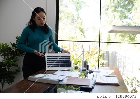 A sales representative presenting solar and wind power, alternative energy, clean energy for future. 129990073