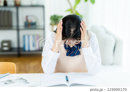 自宅で勉強中に悩む女子高生 129990170