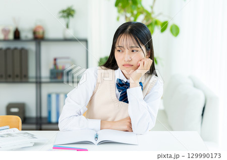 自宅で勉強中に悩む女子高生 129990173