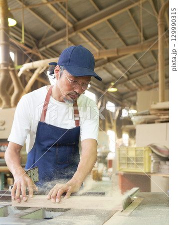丸鋸盤で木材を切断するシニア職人 129990315
