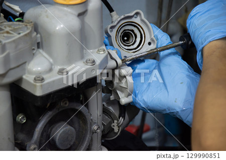 A technician is repairing an old, broken automatic water pump. A technician is repairing an old, broken automatic water pump. 129990851