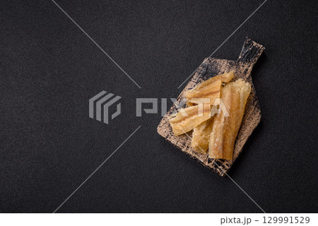 Dried salted fish, snacks or jerky, slices of white fish fillets Dried salted fish, snacks or jerky, slices of white fish fillets 129991529