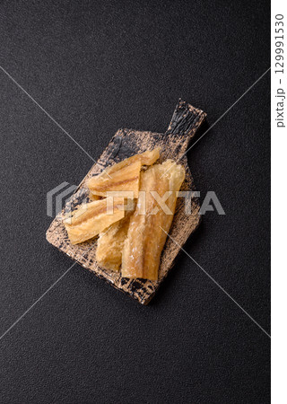 Dried salted fish, snacks or jerky, slices of white fish fillets Dried salted fish, snacks or jerky, slices of white fish fillets 129991530