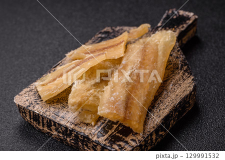 Dried salted fish, snacks or jerky, slices of white fish fillets Dried salted fish, snacks or jerky, slices of white fish fillets 129991532