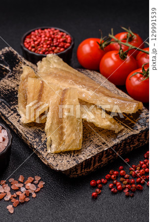 Dried salted fish, snacks or jerky, slices of white fish fillets Dried salted fish, snacks or jerky, slices of white fish fillets 129991539