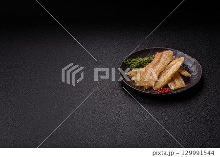 Dried salted fish, snacks or jerky, slices of white fish fillets Dried salted fish, snacks or jerky, slices of white fish fillets 129991544