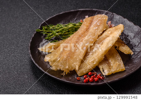 Dried salted fish, snacks or jerky, slices of white fish fillets Dried salted fish, snacks or jerky, slices of white fish fillets 129991548
