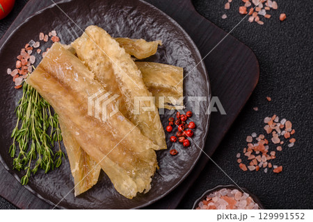 Dried salted fish, snacks or jerky, slices of white fish fillets 129991552
