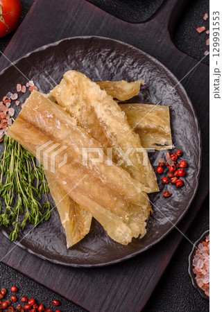 Dried salted fish, snacks or jerky, slices of white fish fillets Dried salted fish, snacks or jerky, slices of white fish fillets 129991553