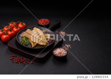 Dried salted fish, snacks or jerky, slices of white fish fillets 129991554